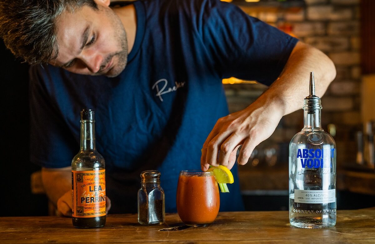 A bartender at Racks Bar & Kitchen in Bristol perfecting a classic Bloody Mary cocktail. Enjoy this signature drink for just £5 every Sunday, paired with a hearty Sunday roast. The best spot in Clifton for Sunday drinks and a relaxed weekend lunch.