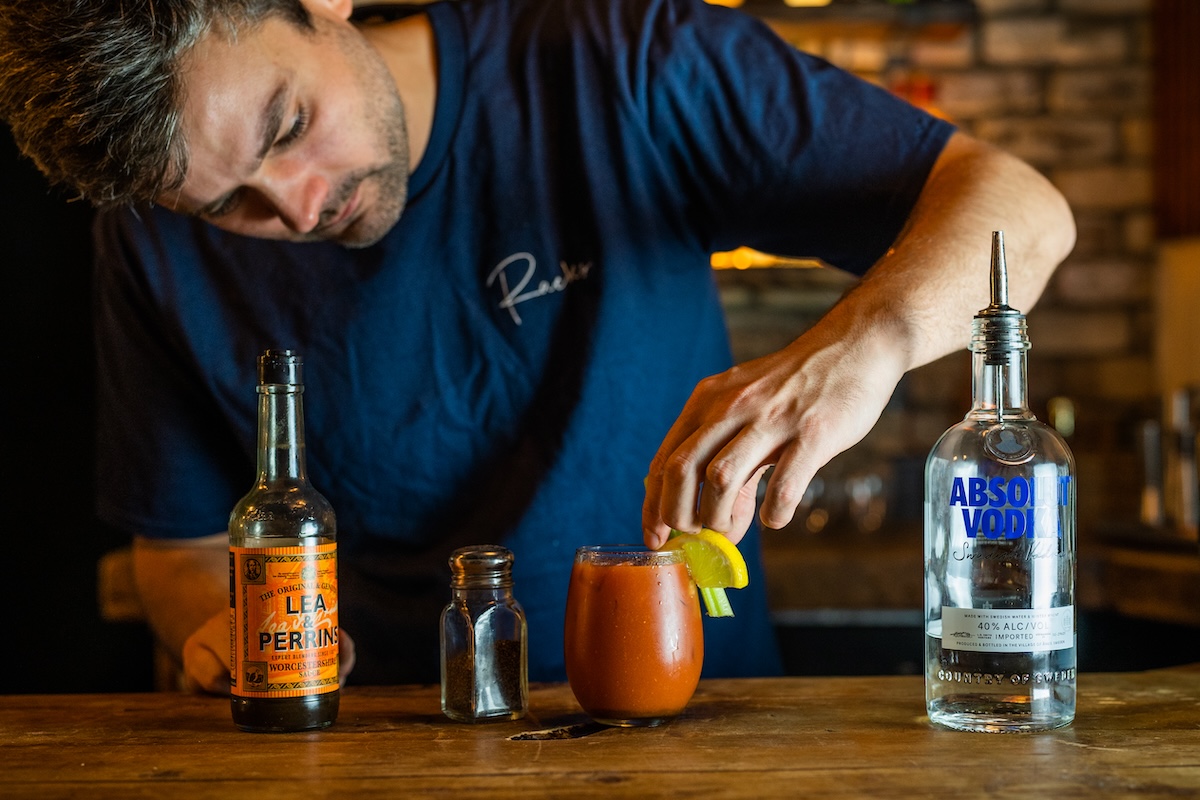 A bartender at Racks Bar & Kitchen in Bristol perfecting a classic Bloody Mary cocktail. Enjoy this signature drink for just £5 every Sunday, paired with a hearty Sunday roast. The best spot in Clifton for Sunday drinks and a relaxed weekend lunch.